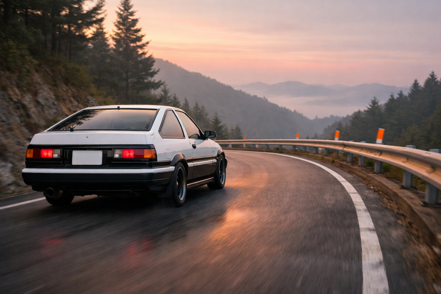 Rear view of a white and black two-tone Toyota AE86 Trueno driving on a mountain pass in Japan at dawn